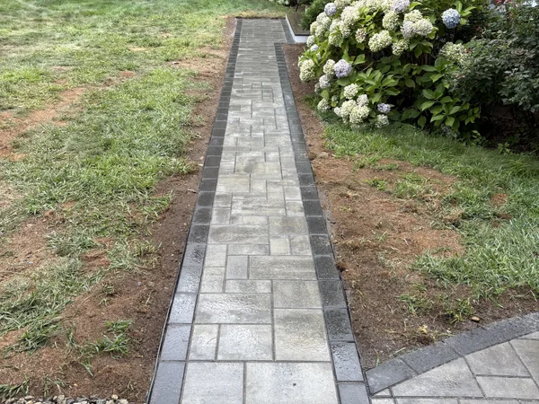 Paver walkway with dark soldier course border by MAC Excavation & Landscape in South Shore MA