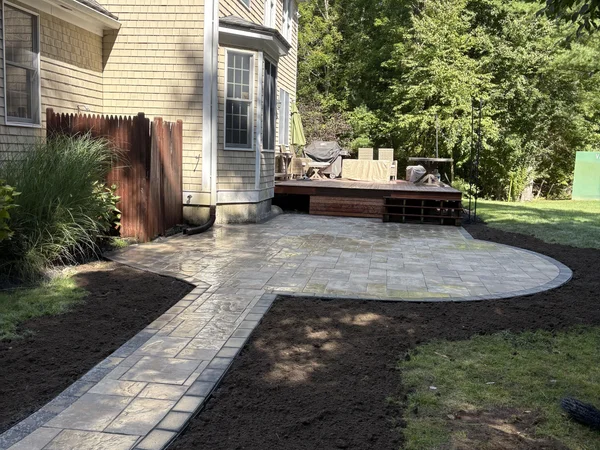 Wide-angle view of custom curved paver patio installation by MAC Excavation & Landscape in South Shore MA
