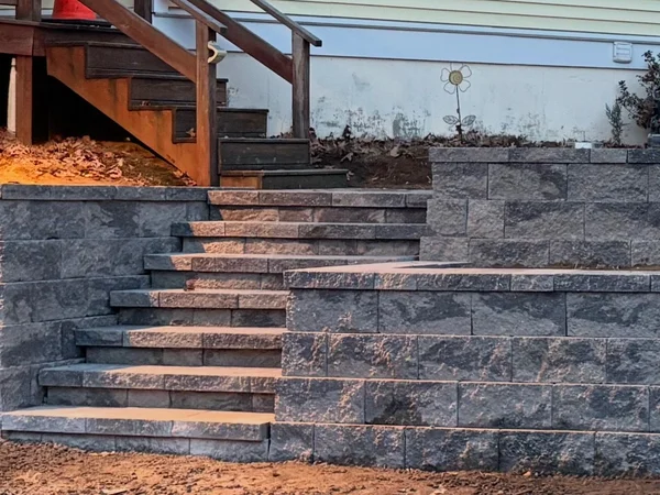Block retaining wall with integrated steps by MAC Excavation & Landscape in South Shore MA