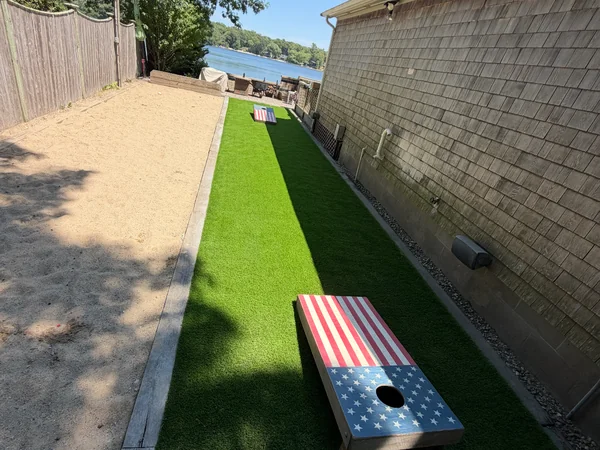 Artificial turf game lane and bocce court installation alongside a home in Plymouth, MA
